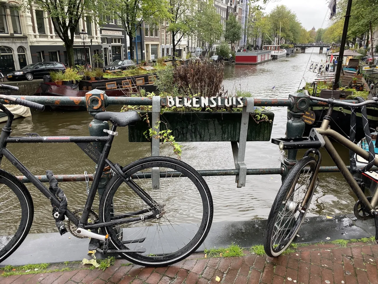 Bikes chained to railings next to a canal.